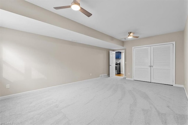 unfurnished bedroom with a closet, carpet flooring, ceiling fan, and baseboards