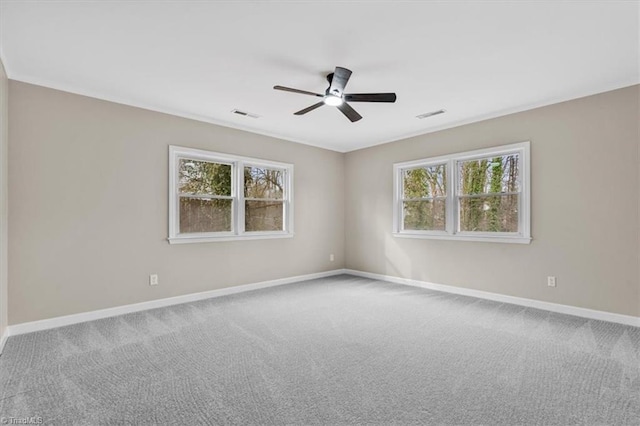 carpeted empty room featuring visible vents, plenty of natural light, and baseboards