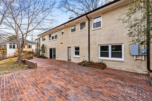 rear view of property with a patio and brick siding