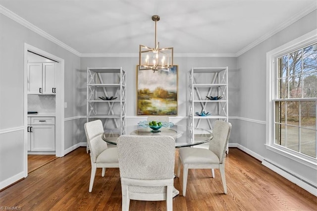 dining room featuring a notable chandelier, wood finished floors, baseboards, baseboard heating, and crown molding