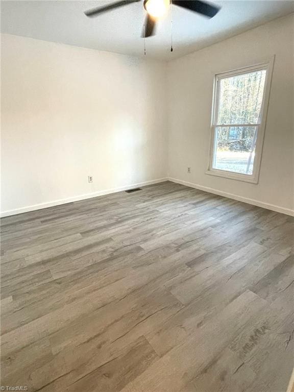 unfurnished room with ceiling fan and hardwood / wood-style floors