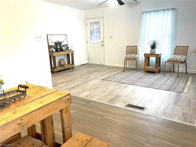 living area with hardwood / wood-style floors and ceiling fan