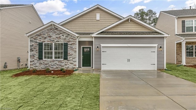 craftsman inspired home featuring a garage, driveway, a front lawn, and stone siding