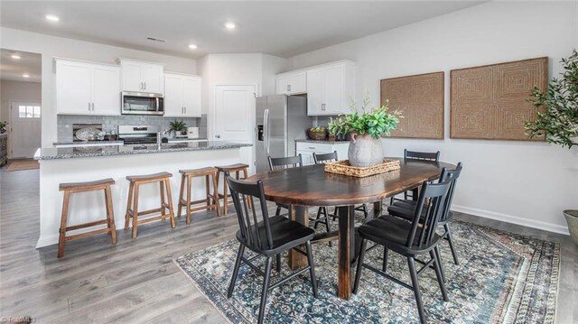 dining space with recessed lighting, baseboards, visible vents, and light wood finished floors