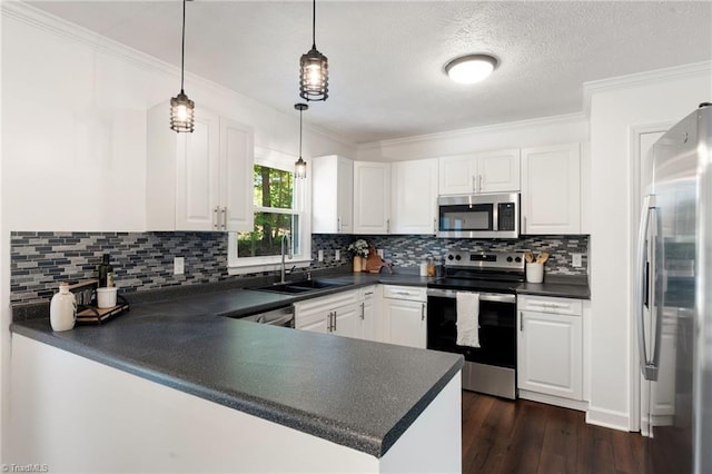 kitchen with appliances with stainless steel finishes, dark countertops, a sink, crown molding, and a textured ceiling