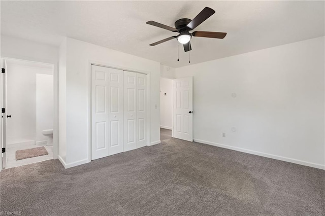 unfurnished bedroom with carpet floors, baseboards, a closet, a ceiling fan, and ensuite bathroom