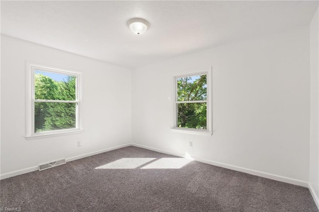 unfurnished room with carpet and baseboards