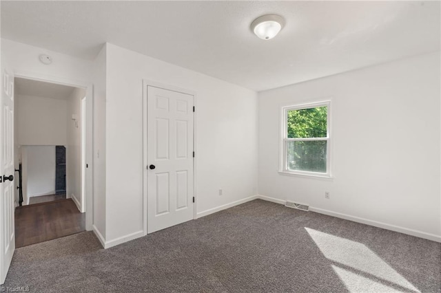 carpeted spare room featuring baseboards and a smoke detector