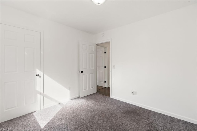 unfurnished bedroom with carpet floors and baseboards