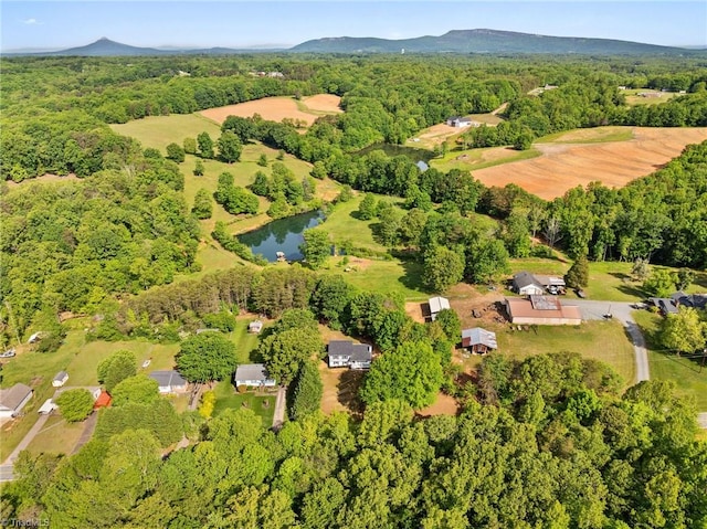 aerial view of property and surrounding area with a heavily wooded area and a large body of water