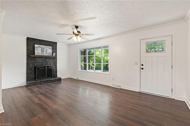 unfurnished living room featuring a textured ceiling, a ceiling fan, dark wood-style floors, baseboards, and a stone fireplace