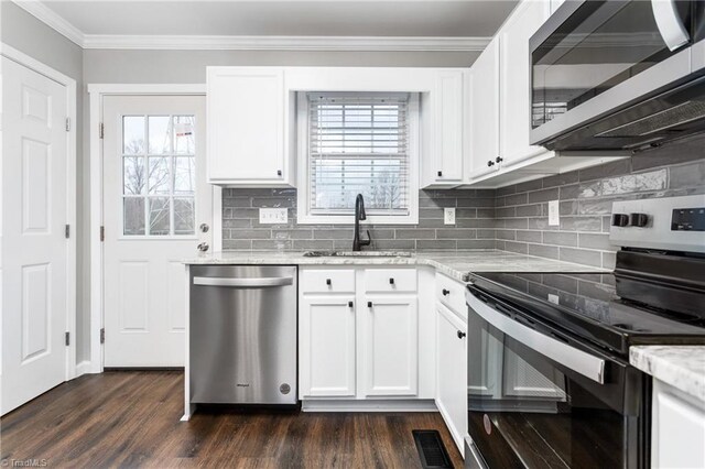 kitchen with light stone countertops, white cabinetry, sink, and appliances with stainless steel finishes