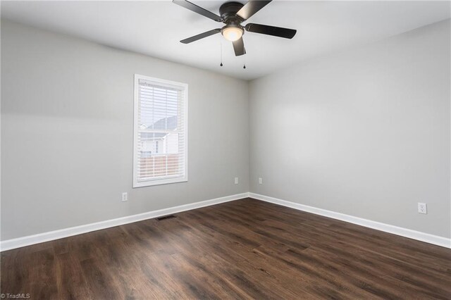 empty room with dark hardwood / wood-style floors and ceiling fan