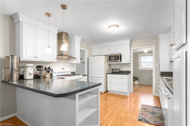 2909 Shamrock Dr, Greensboro, NC 27408 - kitchen with wall chimney exhaust hood, white appliances, a peninsula, dark countertops, and white cabinetry