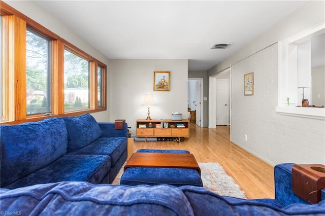 2909 Shamrock Dr, Greensboro, NC 27408 - living room featuring brick wall and wood finished floors