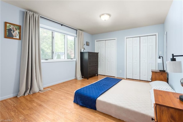 2909 Shamrock Dr, Greensboro, NC 27408 - bedroom with two closets, light wood-style floors, and baseboards