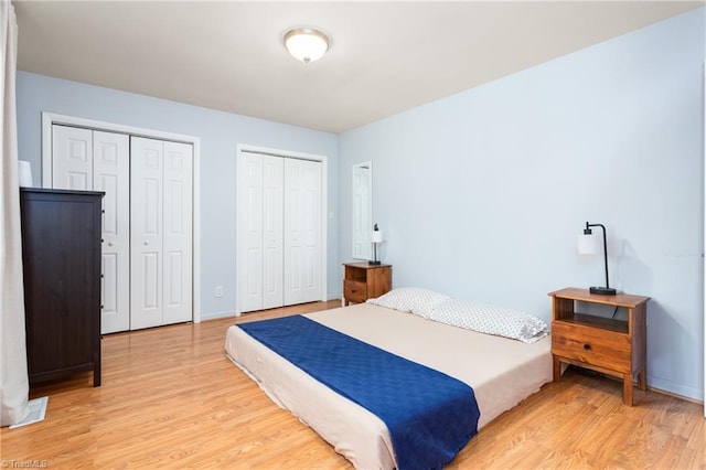 2909 Shamrock Dr, Greensboro, NC 27408 - bedroom featuring multiple closets, light wood-type flooring, and baseboards