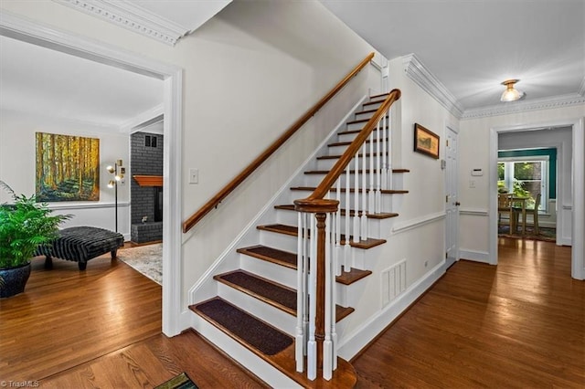 1608 Fox Hollow Rd, Greensboro, NC 27410 - stairway featuring a fireplace, wood finished floors, and crown molding
