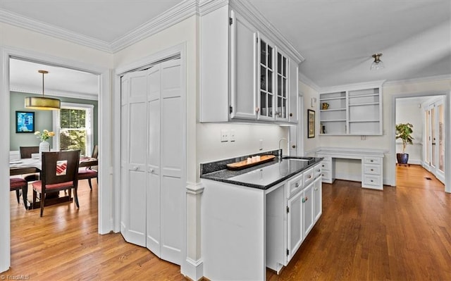 1608 Fox Hollow Rd, Greensboro, NC 27410 - kitchen featuring open shelves, wood finished floors, glass insert cabinets, ornamental molding, and dark stone countertops