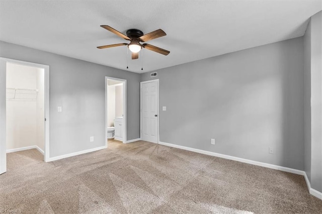 unfurnished bedroom featuring baseboards, carpet, a closet, and a spacious closet