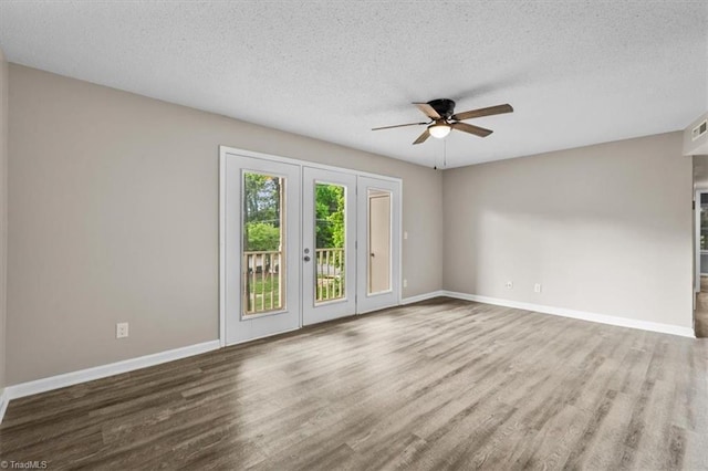 spare room featuring baseboards, a textured ceiling, ceiling fan, and wood finished floors