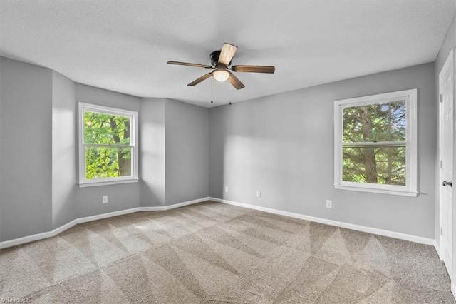spare room with baseboards, carpet flooring, and a ceiling fan