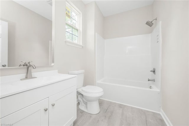 full bath with toilet, washtub / shower combination, vanity, and wood finished floors