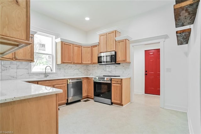 kitchen featuring appliances with stainless steel finishes, light stone countertops, sink, and backsplash