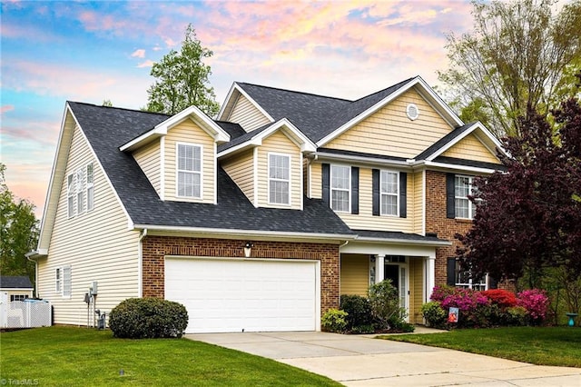 view of front facade featuring a front yard, a shingled roof, an attached garage, concrete driveway, and brick siding