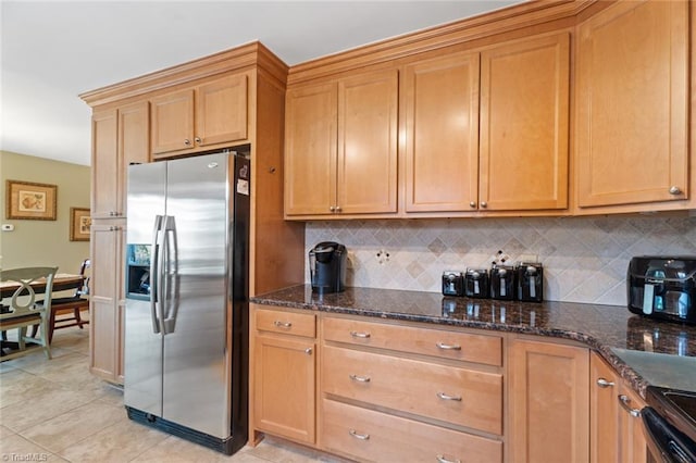 kitchen with decorative backsplash, dark stone counters, stainless steel fridge with ice dispenser, and range with electric cooktop