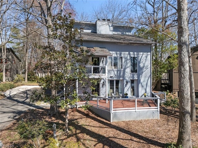 exterior space featuring a balcony and a chimney