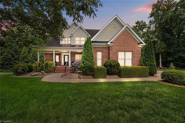 6089 Pleasant Field Dr, Greensboro, NC 27455 - view of front of home with brick siding, a front yard, and covered porch