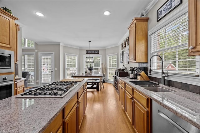 6089 Pleasant Field Dr, Greensboro, NC 27455 - kitchen with a sink, stainless steel appliances, light wood-style flooring, light stone countertops, and ornamental molding