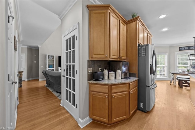 6089 Pleasant Field Dr, Greensboro, NC 27455 - kitchen featuring freestanding refrigerator, light wood finished floors, crown molding, brown cabinets, and tasteful backsplash