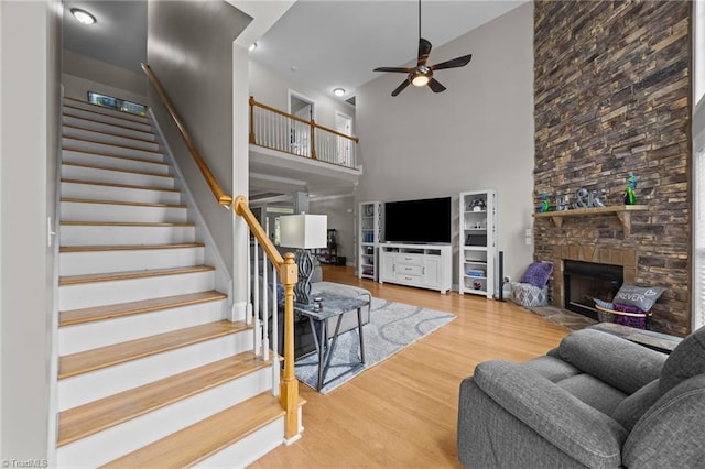 6089 Pleasant Field Dr, Greensboro, NC 27455 - living room featuring a high ceiling, a ceiling fan, stairway, wood finished floors, and a fireplace
