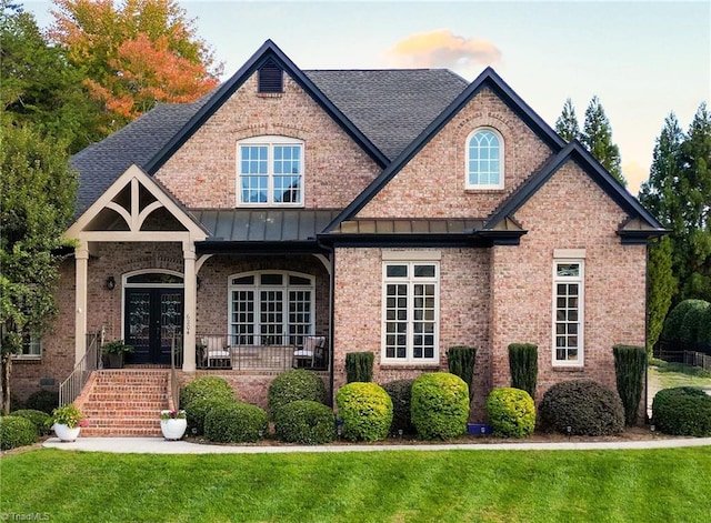 view of front of house with french doors and a lawn