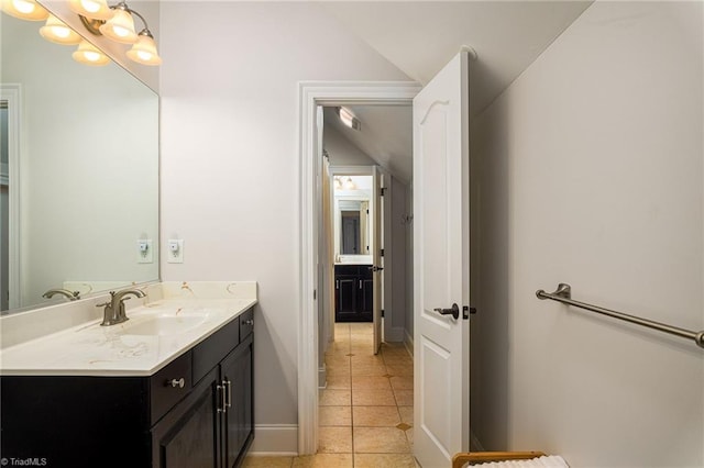 bathroom with vanity, lofted ceiling, and tile patterned flooring