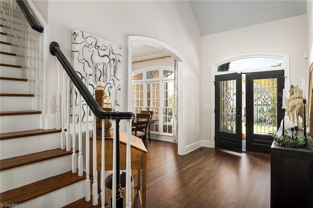 foyer featuring french doors, dark wood-type flooring, plenty of natural light, and vaulted ceiling