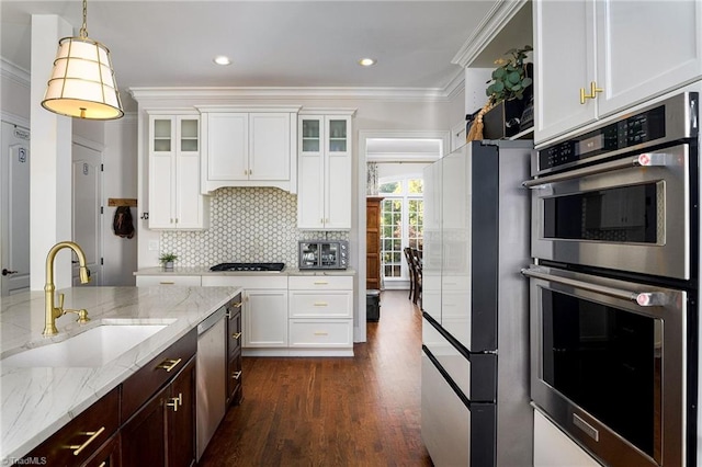 kitchen with white cabinetry, ornamental molding, dark hardwood / wood-style floors, sink, and stainless steel appliances