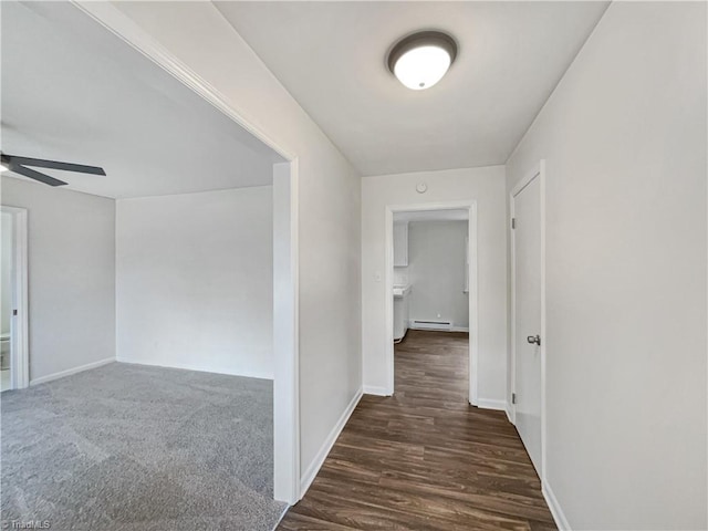 hallway featuring a baseboard heating unit and baseboards