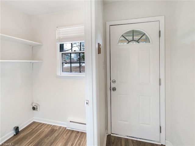 laundry area featuring baseboard heating, wood finished floors, and baseboards