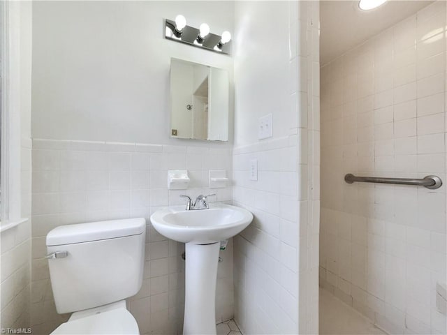 bathroom with a wainscoted wall, tile walls, and toilet