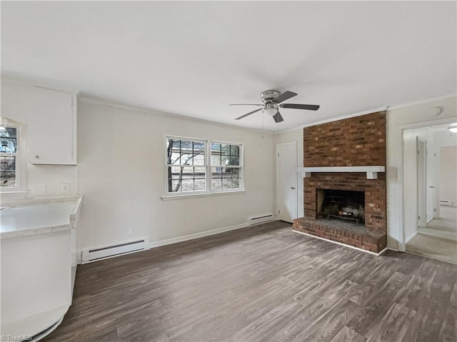 unfurnished living room with a baseboard heating unit, ornamental molding, and wood finished floors