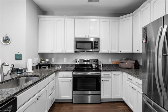 211 Hawks Nest Cir, Clemmons, NC 27012 - kitchen with appliances with stainless steel finishes, white cabinetry, dark stone countertops, and dark wood-style floors