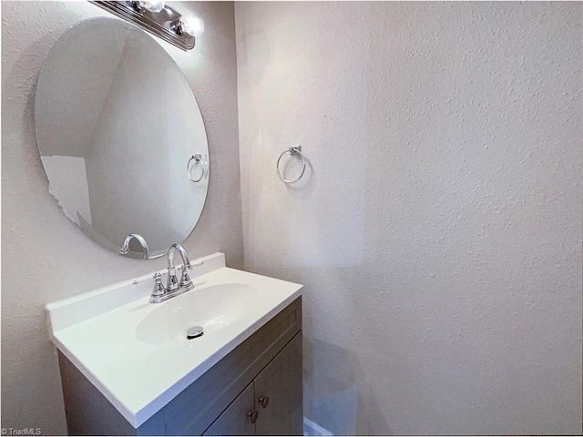 bathroom featuring a textured wall and vanity