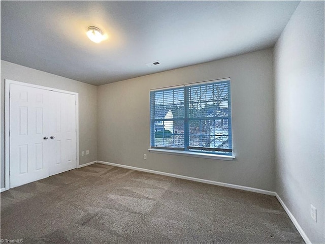 carpeted spare room with baseboards