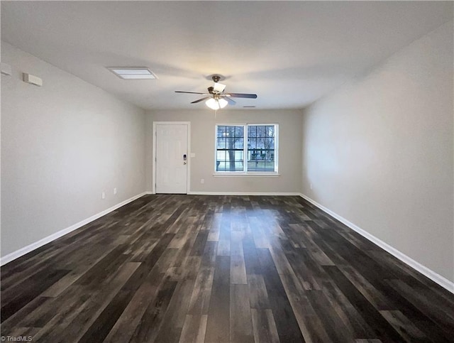 spare room with dark wood-style flooring, ceiling fan, and baseboards