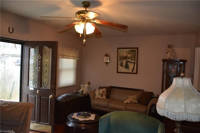 living room featuring a ceiling fan and crown molding