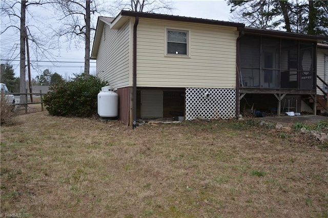 rear view of property with a sunroom, fence, and a yard