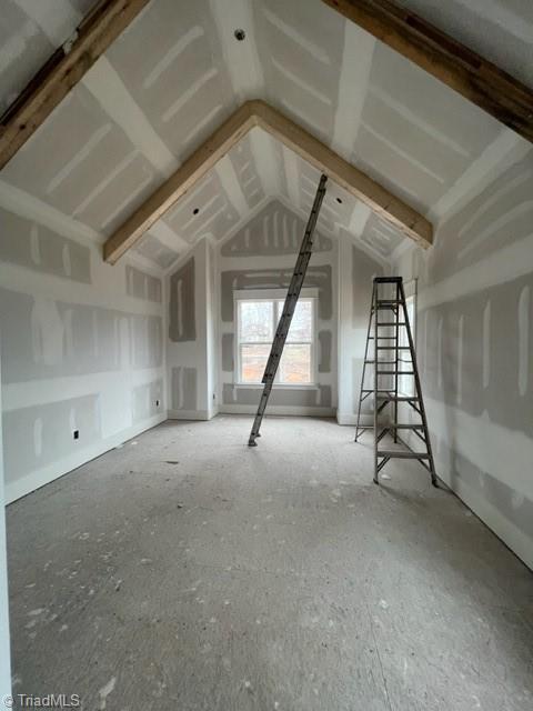 unfurnished living room featuring vaulted ceiling